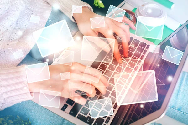 Person typing on a laptop keyboard with digital envelopes representing emails overlaying the image.