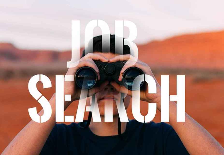 A person looks through binoculars with the words Job Search overlaid on the image, set against a backdrop of an arid, mountainous landscape, symbolizing the pursuit enhanced by Candidate Engagement in modern recruitment.